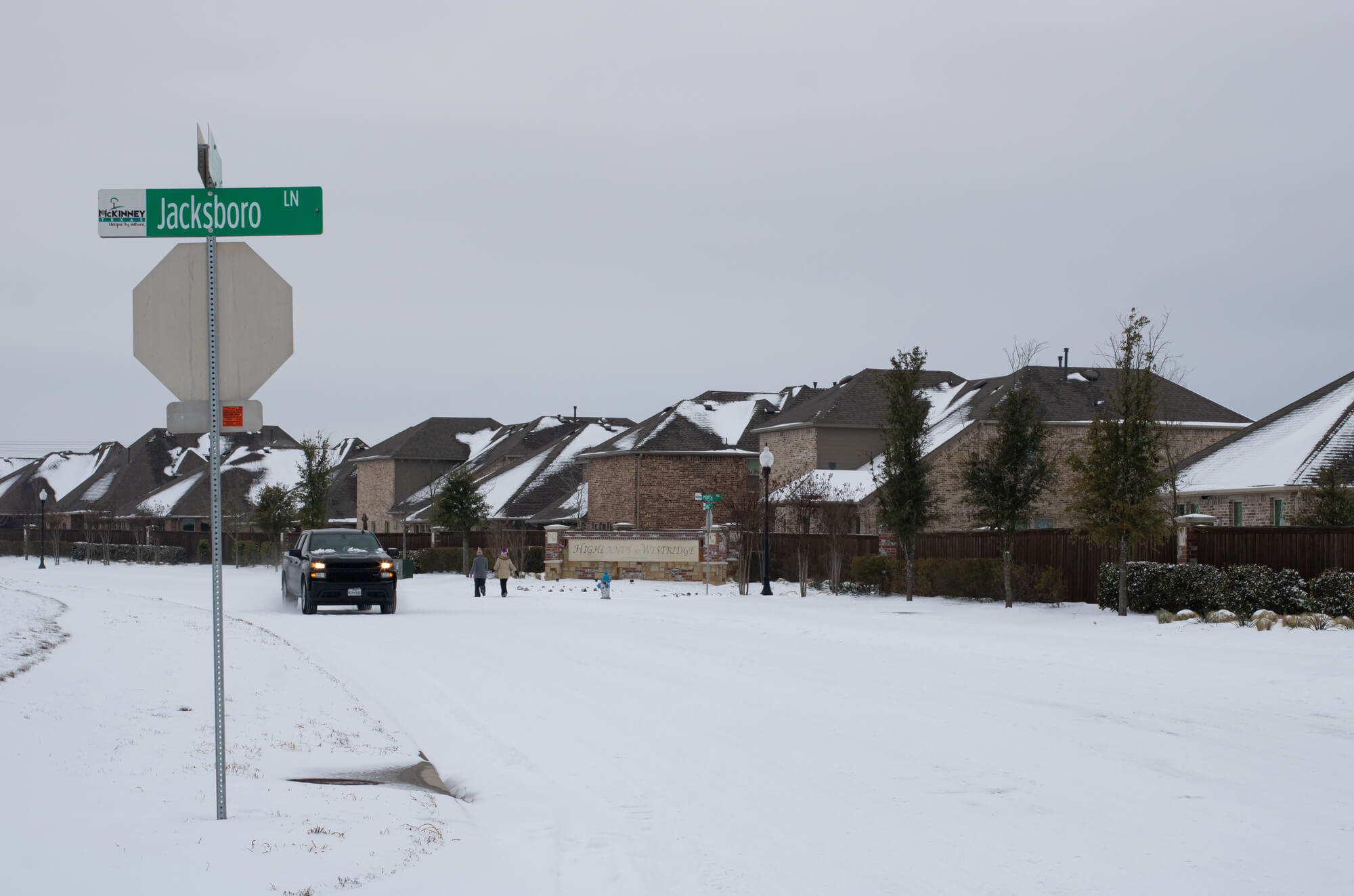 snowy street in texas with houses in need of water damage restoration